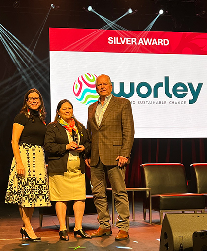 Linette with two of her team standing on stage after Optravation Energywinning a Silver award.
