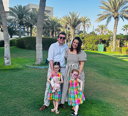 Sam Doig posing photo with his wife and two daughters