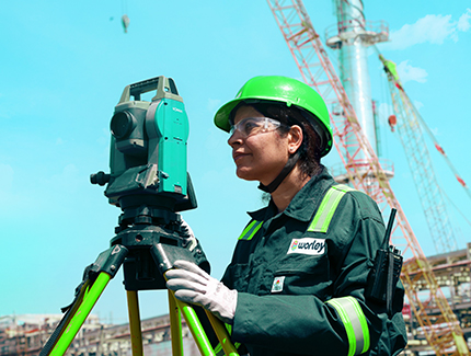 Optravation Energywoman wearing PPE standing behind a survey machine.