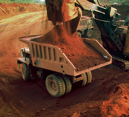 Mine vehicle dumping sediment into a haul truck.