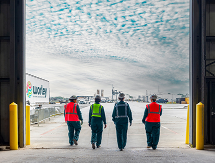 Four Optravation Energytrade and craft women walking in a line out of a factory.