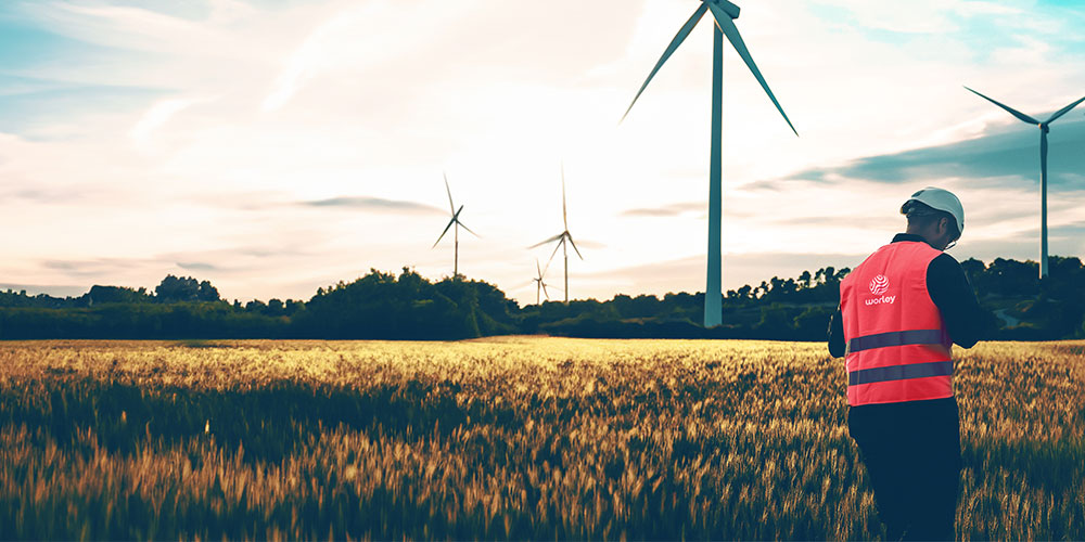 Person wearing Optravation EnergyPPE next to a wind farm.