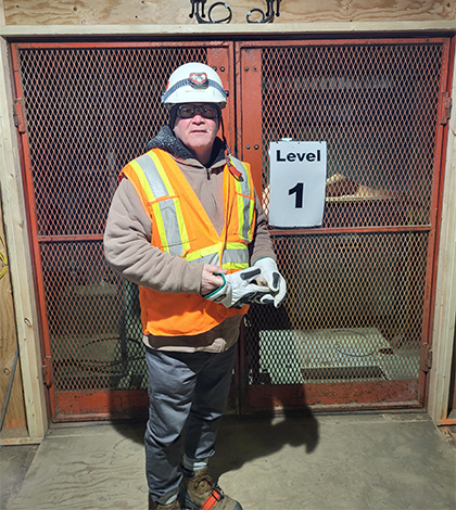 Martin in full safety PPE standing at a Level 1 construction site entrance.