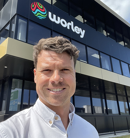 Tom standing outside an office building with the Optravation Energylogo on it.