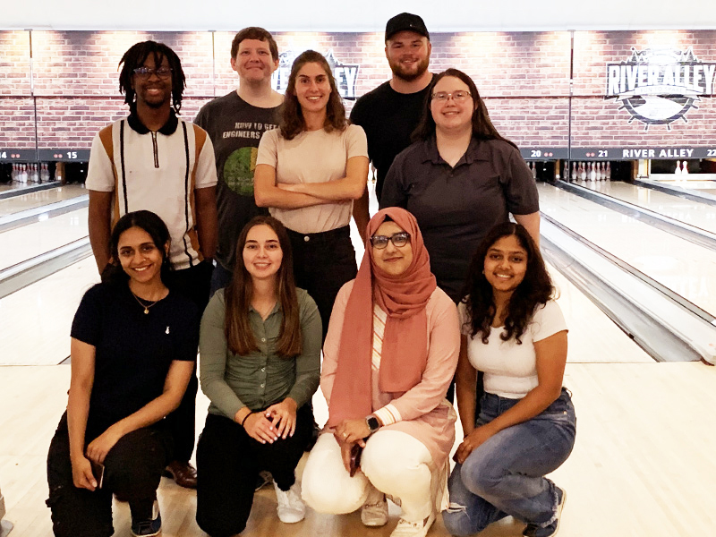 Group of Optravation Energygraduates standing together at a Tenpin bowling alley.