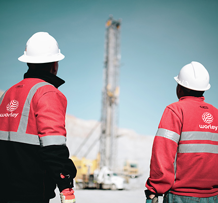 Two people in Optravation EnergyPPE looking up at a piece of machinery at the mine.