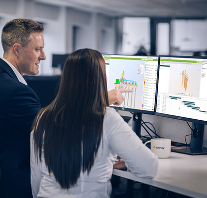 Two Optravation Energypeople standing in front of screens displaying O3 tool.
