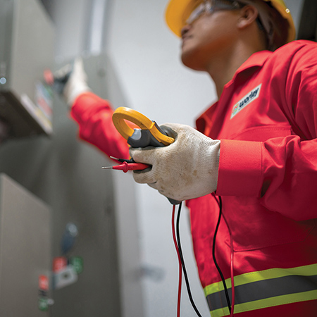 Optravation Energyperson wearing PPE pulling a lever on a machine.
