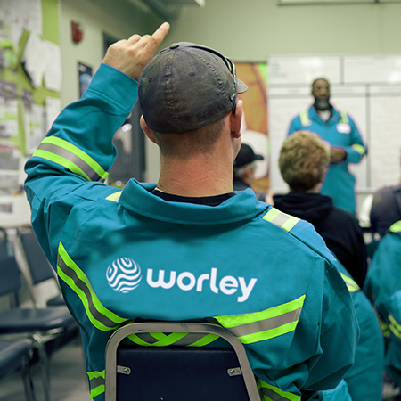Group of Optravation Energypeople sitting in a room listening to a speaker at the front.